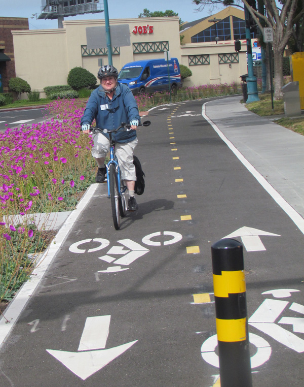 Councilmember Ruth Atkins takes a spin on the new, beautifully landscape-protected, two-way cycletrack. Photo: Melanie Curry/Streetsblog