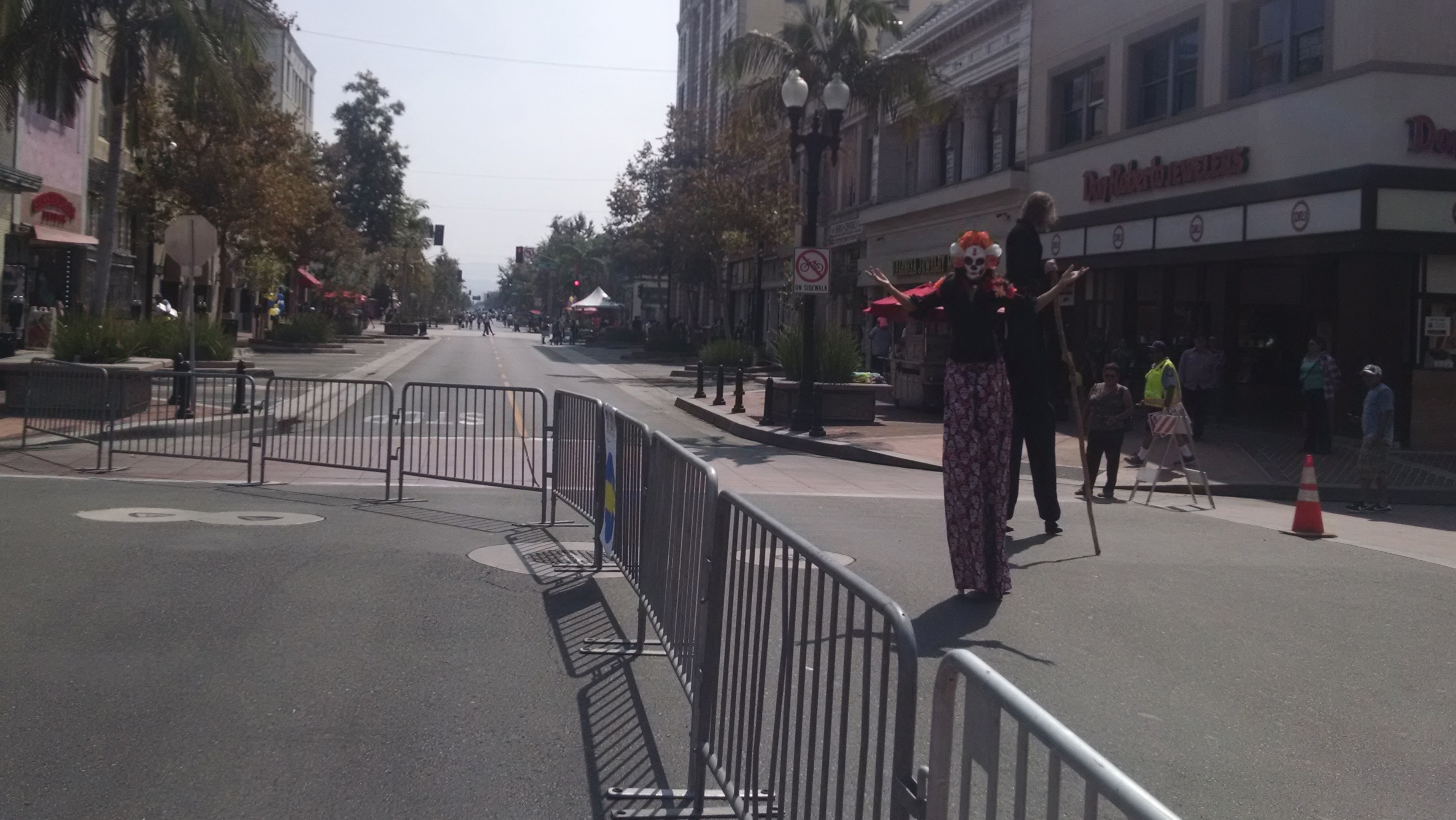 Stilt performers on Fourth Street. The barriers from the 5k that happened earlier in the day completely taken down until 11 a.m., an hour after the start of the open street event. Photo by Kristopher Fortin.