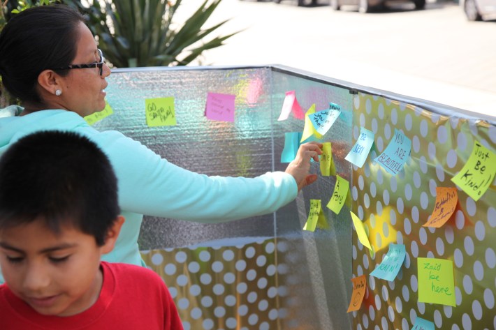 Margarita Solis, 39, adds a wish to the wishing wall at North Orange County's (Park)ing Day event. Photo by Kristopher Fortin