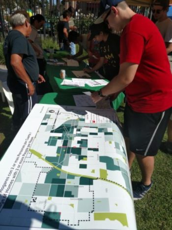 Residents look over a map showing proximity of vacant city-owned lots in Santa Ana to housing density. Photo by Kristopher Fortin