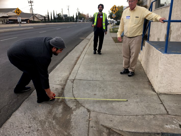 Peter Smith, regional planner with the Kern Council of Governments,  watches as the curb is measured during a walk audit in Bakersfield. Photo courtesy of California Walks.