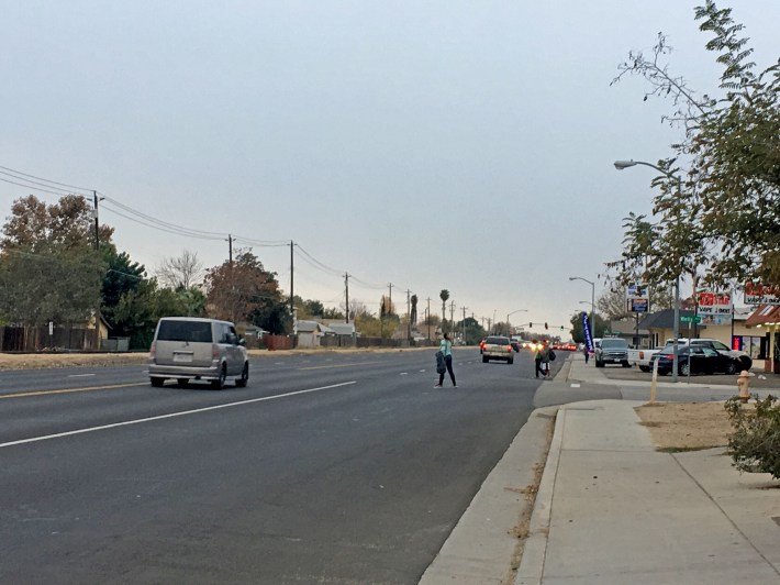 A walk audit identifies everyday challenges pedestrians face like this woman waiting  for an opportunity to cross Norris Road at Wells Avenue in Bakersfield on Nov. 30. Photo courtesy California Walks.