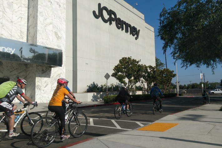 The OCTA Bike Rally passing a JCPenny at the Main Place Mall. The Santiago Creek Bike Path turns off toward the Mall, which is adjacent to OCTA headquarters.
