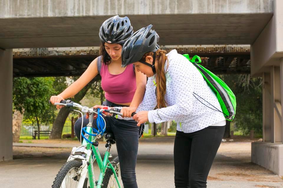 SAAS member Rosario "Charis" Perez, left, helps Mary Leopo with her bike during a SAASy Mujeres ride.
