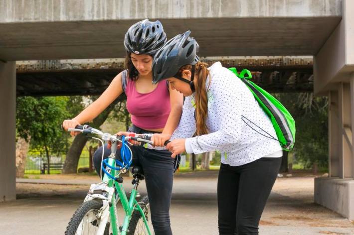 SAAS member Rosario "Charis" Perez, left, helps Mary Leopo with her bike during a SAASy Mujeres ride.
