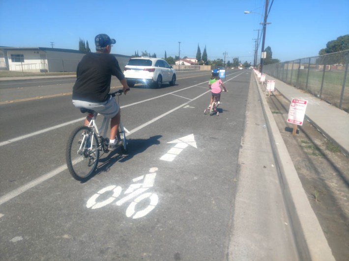 Bicyclists ride north on a modified Ward Street bike lane in Garden Grove. Ward Street existing design has car parking against the curb and a bike lane adjacent to the parking, but Saturdays event temporary replaced the car parking with a curbside bike lane and painted buffer. Kristopher Fortin/Streetsblog CA