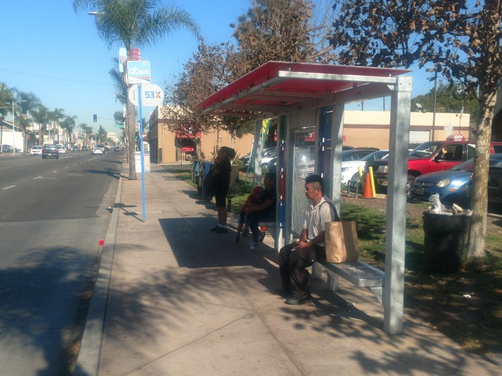 Bus riders wait for a bus on Main Street, adjacent to McFadden Avenue. Kristopher Fortin/Streetsblog CA
