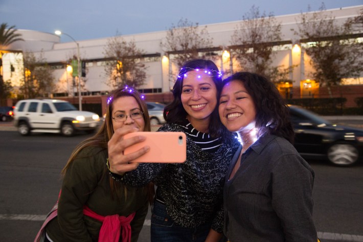 From left, SAAS members Charis Galeas, Lynnete Guzman, Karen Galindo take a selfie before the start of the Walk of Lights. Image: Santa Ana Active Streets