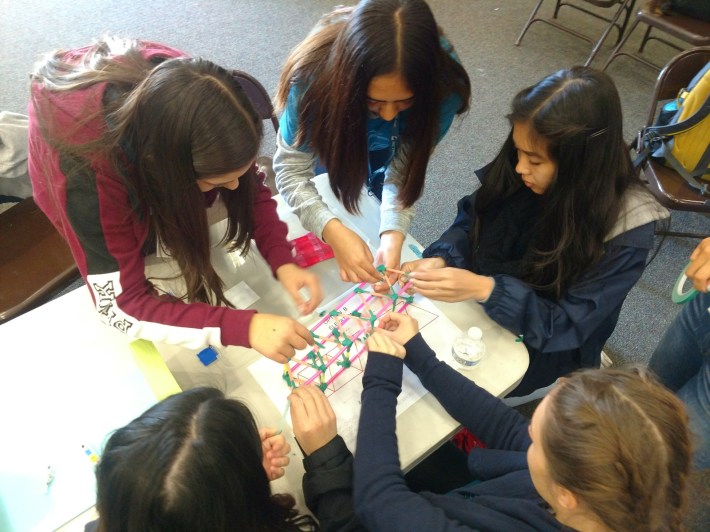 Students at Girls'Engineering Day build a suspended bridge made out of straws and popsicle sticks. Working with two designs, the girls had to see which would be better to hold the weight of multiple juice boxes. Streetsblog CA/Kristopher Fortin