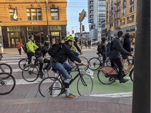 ten or so bike riders waiting for a green light on Market st in SF