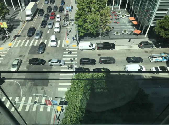 overhead shot of pedestrians trying to use crosswalk in SF, with cars blocking cross traffic