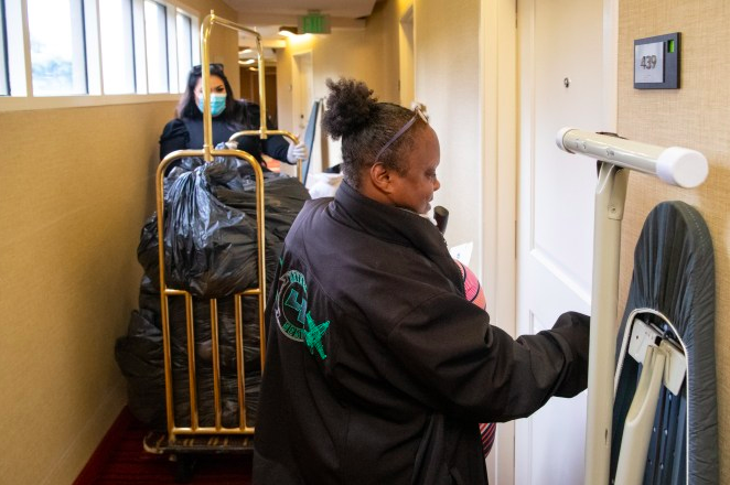 A woman unlocks the door to an apartment