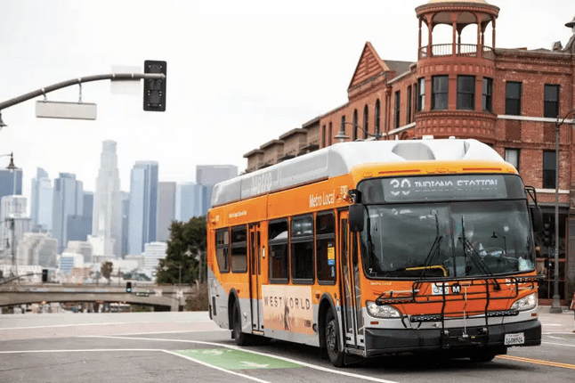 Orange Metro bus with LA skyline in background