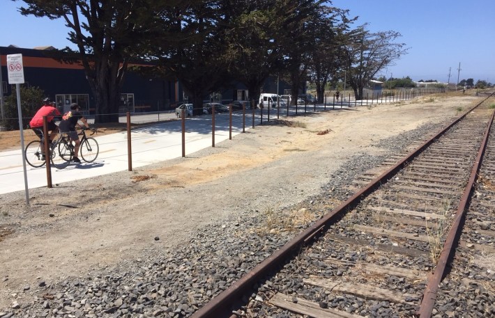 The recently-opened walk/bike path runs along rail tracks
