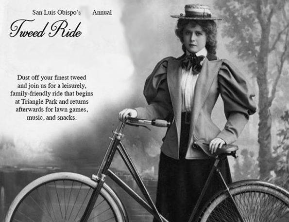 A nattily dressed woman with a beribboned hat and 1890s-era dress stands behind a bicycle