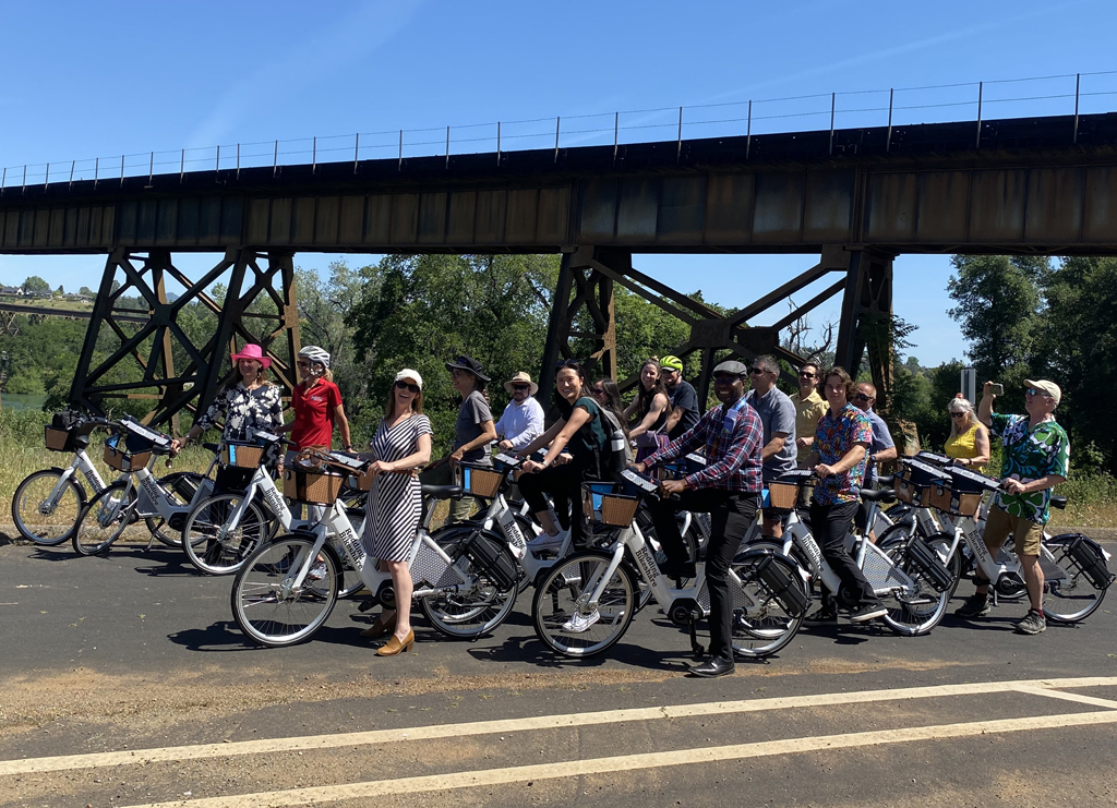 One of the e-bike tours of Redding's bike routes. Joining was Anne Thomas (in the pink hat), Lynn von Koch-Liebert, ED of the Strategic Growth Council (wearing the striped dress), John Ando, GM of the Redding Area Bus Authority (dapper in his flat cap), and long-time bike advocate Jim Brown (taking a picture). Photo: Melanie Curry/Streetsblog