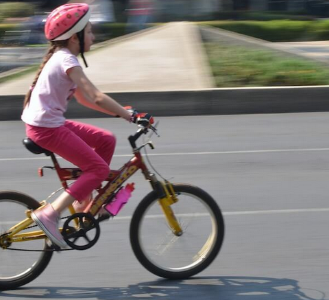Girl wearing pink rides a bike